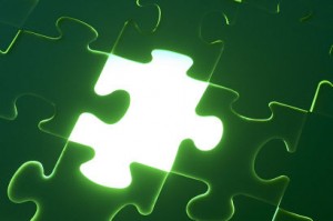 Green puzzle with missing piece shining with white light
